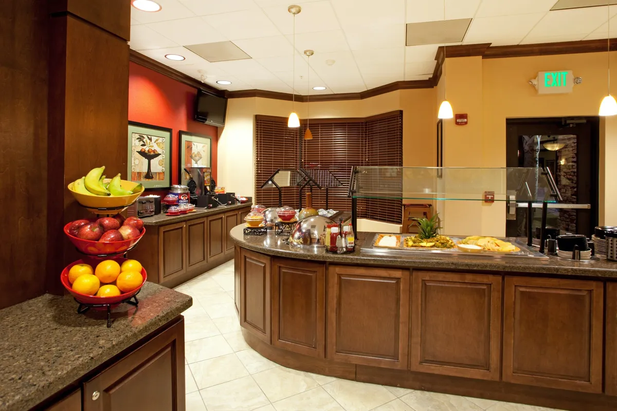 A cheerful breakfast bar area with a fruit bowl, an inviting serving area, and warm artwork, creating a friendly and communal setting that encourages starting the day with a hearty meal.